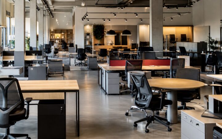 Interior de showroom de móveis corporativos com cadeiras, mesas e estações de trabalho